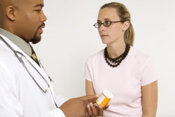 Nursing assistant giving medication to a patient